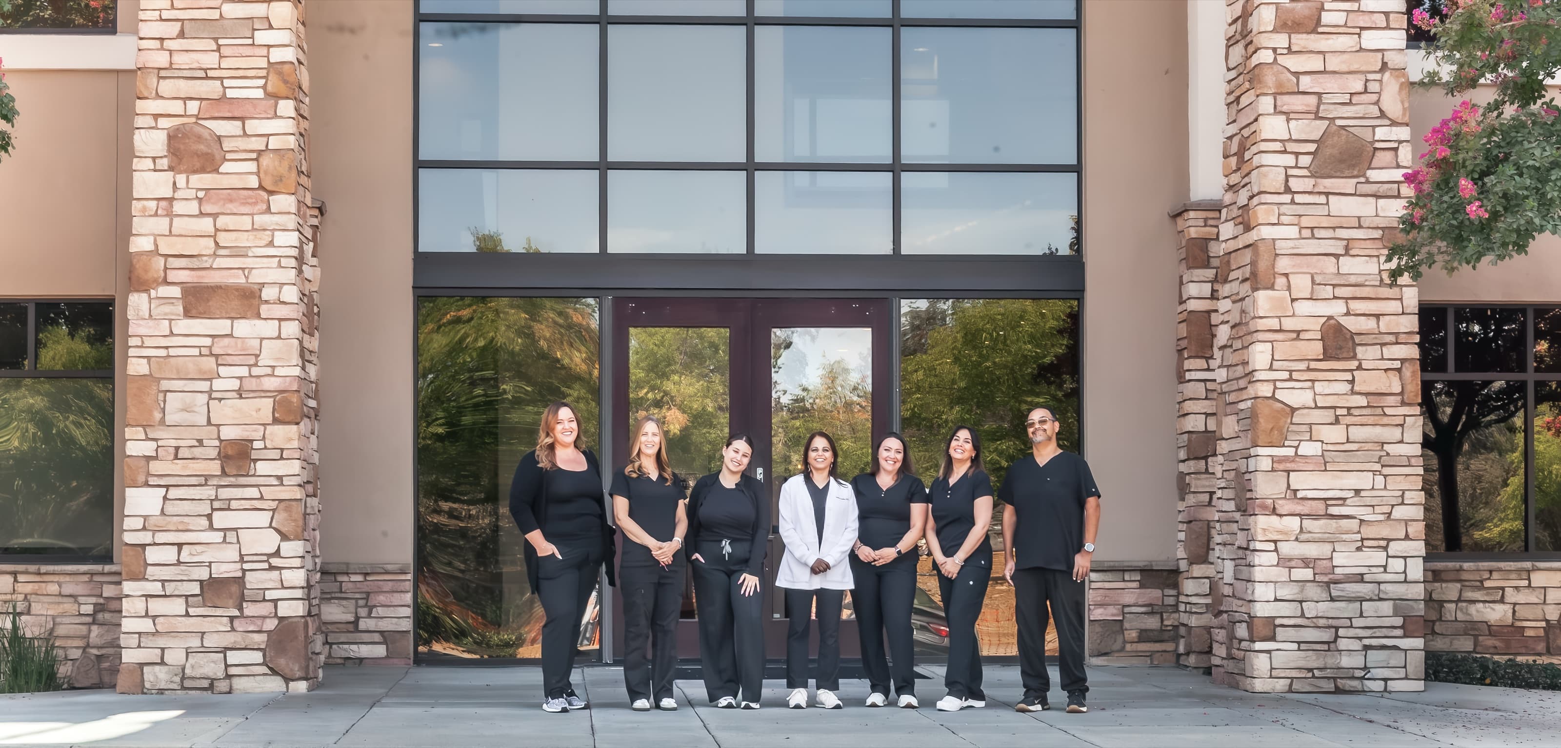 Dr. Henna Sandhu and the Folsom Dental team at the office entrance